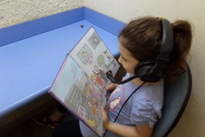 ילדה קוראת ספר עם אוזניות